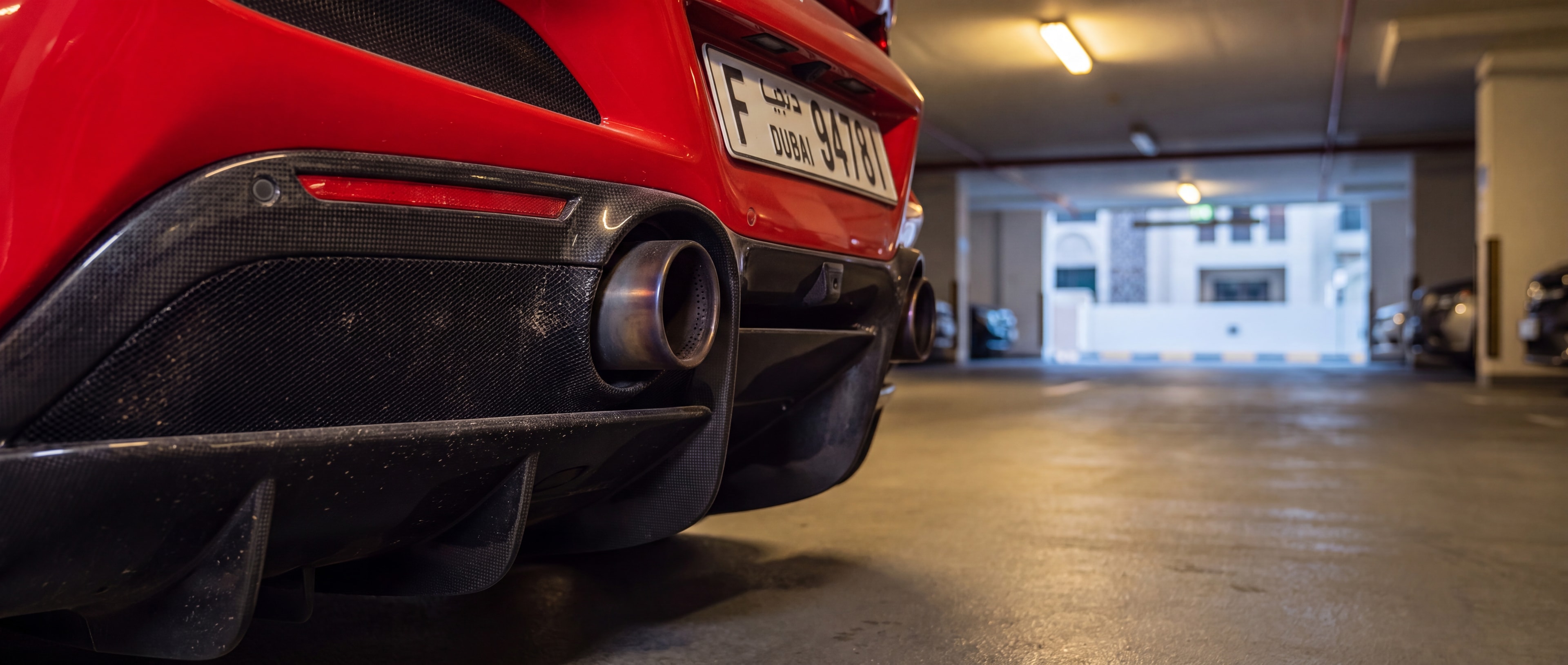 Ferrari F8 Tributo Spyder rear exhaust and diffuser detail, underground parking gallery
